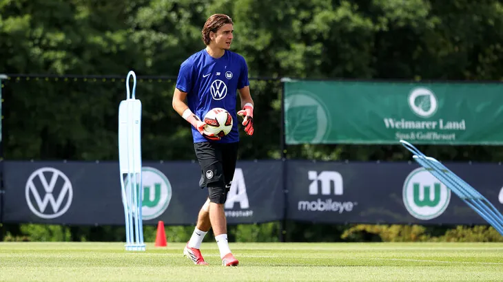 VfL-Wolfsburg-Torwart Jakub Zieliński hält im Training einen Ball.